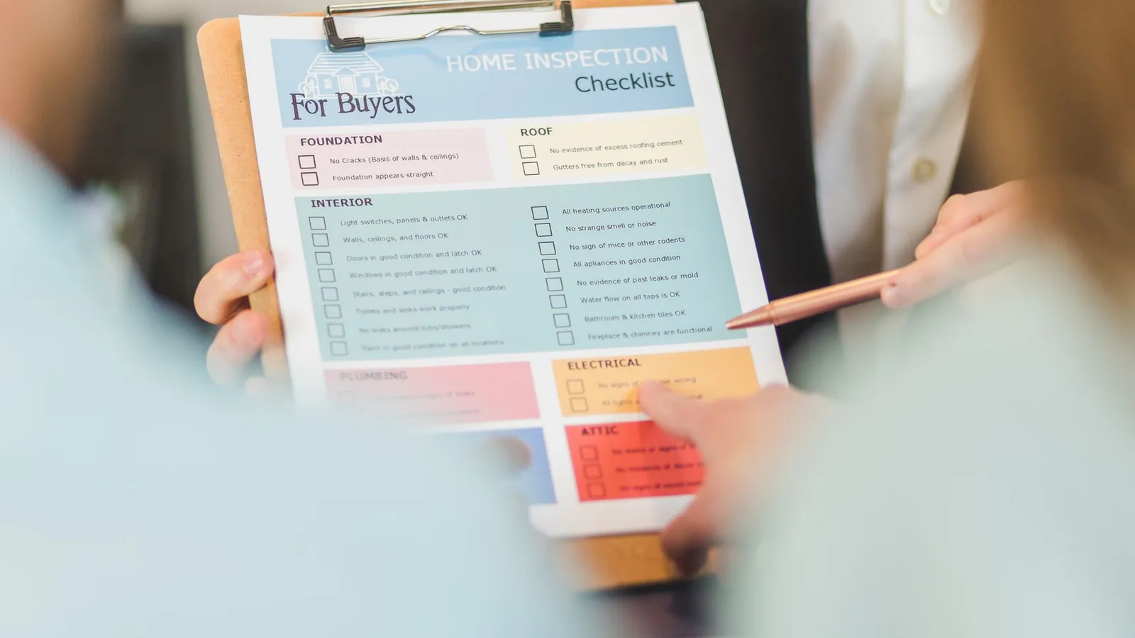 Handen met een checklist voor een woninginspectie op een klembord