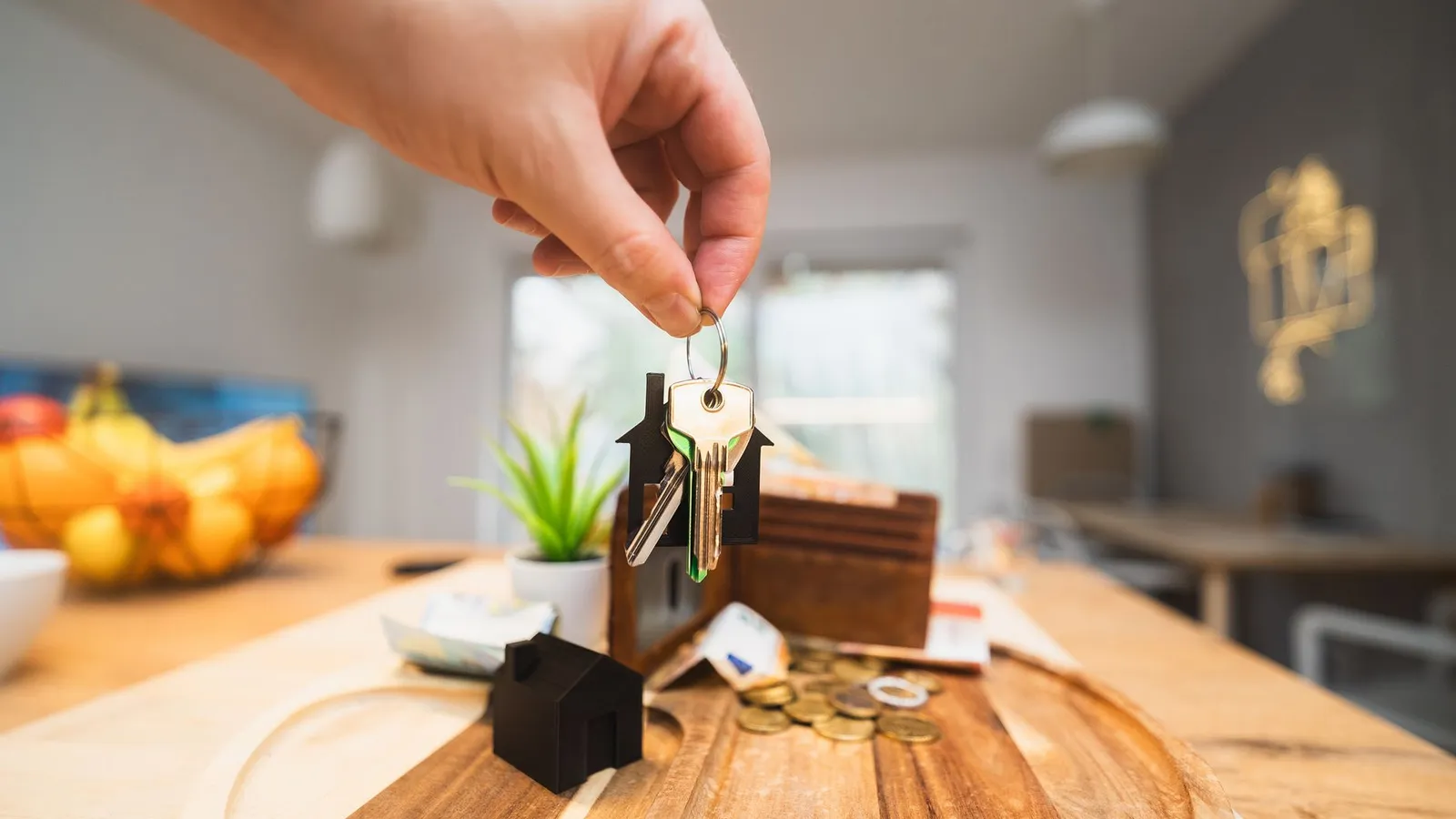 Hand met de sleutels van een nieuw gekochte woning in een lichte woonkamer