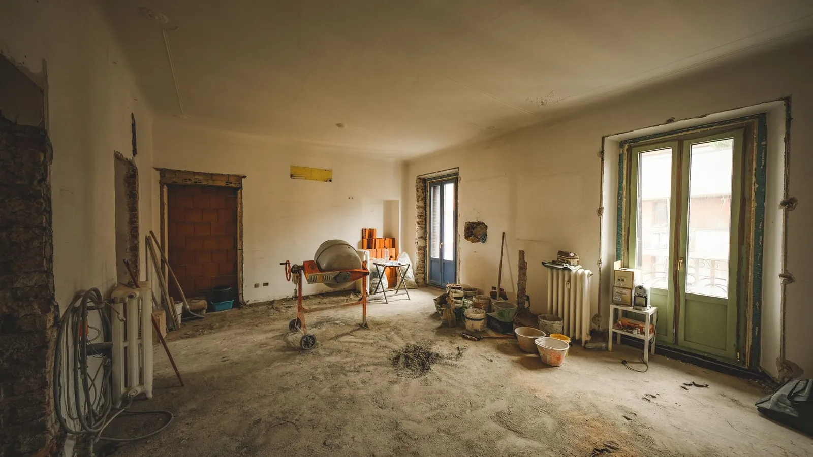 Zonnige kamer tijdens een verbouwing, met bouwmaterialen en gereedschap op de vloer